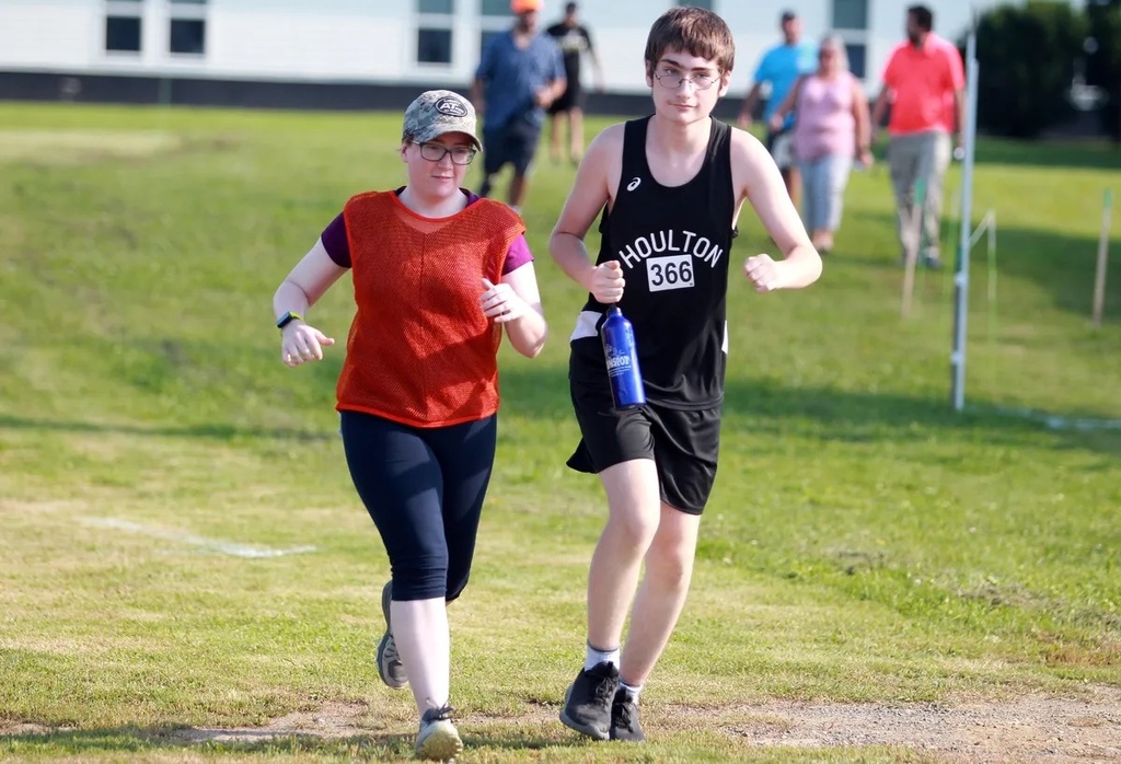 Ethan runs along side Mrs. Dyer in Cross Country